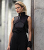 edgy female model wearing badami leather vest harness with leather scarf worn as a wrist cuff